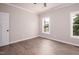 Simple bedroom with hardwood floors and two windows at 1845 N Main St, Roxboro, NC 27573