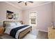 Spacious bedroom with a king-size bed, light wood nightstands and a ceiling fan at 1849 N Main St, Roxboro, NC 27573