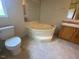 Bathroom with corner bathtub and toilet at 910 Vanco Mill Rd, Henderson, NC 27537