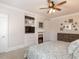 Main bedroom with fireplace, built-in shelving, and ceiling fan at 209 E Whitaker Mill Rd, Raleigh, NC 27608