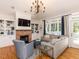 Spacious living room with a fireplace, built-in shelving, hardwood floors and large windows at 209 E Whitaker Mill Rd, Raleigh, NC 27608