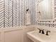 Stylish powder room with blue chevron wallpaper and white sink at 209 E Whitaker Mill Rd, Raleigh, NC 27608
