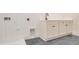 Laundry room featuring white cabinets and a utility sink at 212 Meadow Walk Dr, Fuquay Varina, NC 27526
