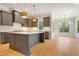 Modern kitchen with dark cabinetry, quartz countertops, and a large island at 212 Meadow Walk Dr, Fuquay Varina, NC 27526