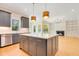 Open kitchen with island, stainless steel appliances, and hardwood floors at 212 Meadow Walk Dr, Fuquay Varina, NC 27526