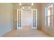 Spacious office with hardwood floors, chandelier, and French doors at 212 Meadow Walk Dr, Fuquay Varina, NC 27526