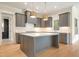 Modern kitchen with island, stainless steel appliances, and hardwood floors at 212 Meadow Walk Dr, Fuquay Varina, NC 27526