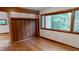 Bright bedroom with wood floors, built-in shelving, and large windows at 2308 Wabash Rd, Chapel Hill, NC 27516