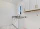 Well-appointed laundry room with white cabinets and granite countertop at 46 Otter Hole Dr, Princeton, NC 27569