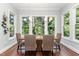 Sunlit dining room with wooden table and chairs, overlooking the backyard at 9 Mist Wood Court, Pittsboro, NC 27312