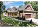 House exterior showcasing stone, wood siding, and a two-car garage at 9 Mist Wood Court, Pittsboro, NC 27312