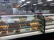 Assortment of fresh donuts, pastries, and cookies displayed in a glass case at Lot C N King Ave, Dunn, NC 28334