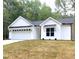 White farmhouse style home with black accents and a two car garage at 114 Shoshone Dr, Louisburg, NC 27549