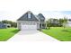 Two-story house with gray siding, stone accents, and a large front yard at 236 Abingdon Farms Dr, Selma, NC 27576