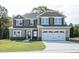 Two-story house with a large white garage door and landscaping at 168 Newport Lndg, Garner, NC 27529