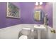 Small powder room with pedestal sink, toilet, and decorative mirror at 1001 Yopon Ct, Raleigh, NC 27603