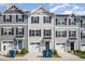 Three-story townhouses with gray siding and two-car garages at 1109 Pale Moss Dr, Durham, NC 27704