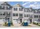 Three-story townhouses with gray siding and two-car garages at 1109 Pale Moss Dr, Durham, NC 27704