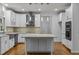 Modern kitchen with white cabinets, granite island, and stainless steel appliances at 111 N Coslett Ct, Cary, NC 27513
