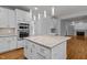 Modern kitchen with white cabinets, granite island, and stainless steel appliances at 111 N Coslett Ct, Cary, NC 27513