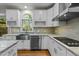 Modern kitchen with white cabinets, granite countertops, and stainless steel appliances at 111 N Coslett Ct, Cary, NC 27513