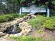 Lake Royale entrance with cascading waterfall and landscaping at 102 Mayan Dr, Louisburg, NC 27549