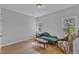 Bright bedroom with hardwood floors, two windows, and a chaise lounge at 1100 Branch Chapel Church Rd, Selma, NC 27576