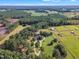 Aerial view showing house, expansive lawn, and horse stables on a large property at 1100 Branch Chapel Church Rd, Selma, NC 27576