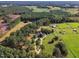 Aerial view of home on a spacious lot with a circular driveway, stables, and lush pastures at 1100 Branch Chapel Church Rd, Selma, NC 27576