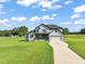 Two-story farmhouse with white siding, black accents, and a long driveway at 2804 Jack Mitchell Rd, Zebulon, NC 27597