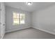 Well-lit bedroom with carpet flooring, large window, and double doors at 100 Carol Cir, Louisburg, NC 27549