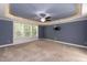 Main bedroom with blue walls, lighted tray ceiling, and neutral carpet at 159 Shady Oaks Dr, Benson, NC 27504