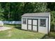 White storage shed with black trim in the backyard at 159 Shady Oaks Dr, Benson, NC 27504