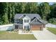 Two-story house with stone accents, a large yard, and a two-car garage at 159 Shady Oaks Dr, Benson, NC 27504