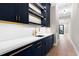 Modern wet bar with dark cabinetry, quartz countertops, and gold accents at 5406 Garrett Rd, Durham, NC 27707