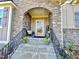 Stone and wood front door with a welcoming porch and steps at 6424 Sunset Manor Dr, Wake Forest, NC 27587