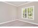 Simple bedroom with neutral wall colors and a large window with woodland views at 2074 Burch Bridge Rd, Burlington, NC 27217