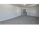 Empty bedroom with gray carpet, white walls, and open doors at 42 Decatur Dr, Fuquay Varina, NC 27526