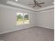 Spacious bedroom with plush carpet, tray ceiling, and window with natural light at 98 Kipling Creek Dr, Fuquay Varina, NC 27526