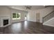 Living area with fireplace, staircase, wood-like floors, and open concept layout at 98 Kipling Creek Dr, Fuquay Varina, NC 27526