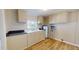 Galley kitchen with light cabinets and laminate flooring at 5141 Nc 56, Franklinton, NC 27525