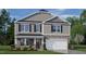 Two-story home with stone and siding exterior, two-car garage and landscaping at 6421 Alfalfa Ln, Wake Forest, NC 27587