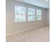 Spacious bedroom with three windows and neutral carpeting at 7717 Litcham Dr, Raleigh, NC 27615