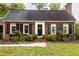 Brick home with shutters, a welcoming front porch, and well-manicured landscaping at 615 Beaver Creek Rd, Apex, NC 27502