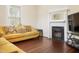 Living room with yellow couch, fireplace and hardwood floors at 1502 Bahama Rd, Bahama, NC 27503