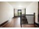 Long hallway with hardwood floors, two chairs, and a staircase at 1502 Bahama Rd, Bahama, NC 27503