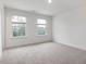 Bright, empty bedroom with large windows and neutral carpeting at 1208 Randwick Valley Ct, Zebulon, NC 27597