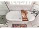 Freestanding bathtub with wooden tray and hexagon tile flooring at 997 Jackson Rd, Fuquay Varina, NC 27526
