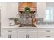 Modern kitchen with white cabinets, gas cooktop and wooden range hood at 997 Jackson Rd, Fuquay Varina, NC 27526