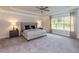 Bright main bedroom with plush carpeting and a ceiling fan at 591 Glenkirk Pl # 106, Garner, NC 27529